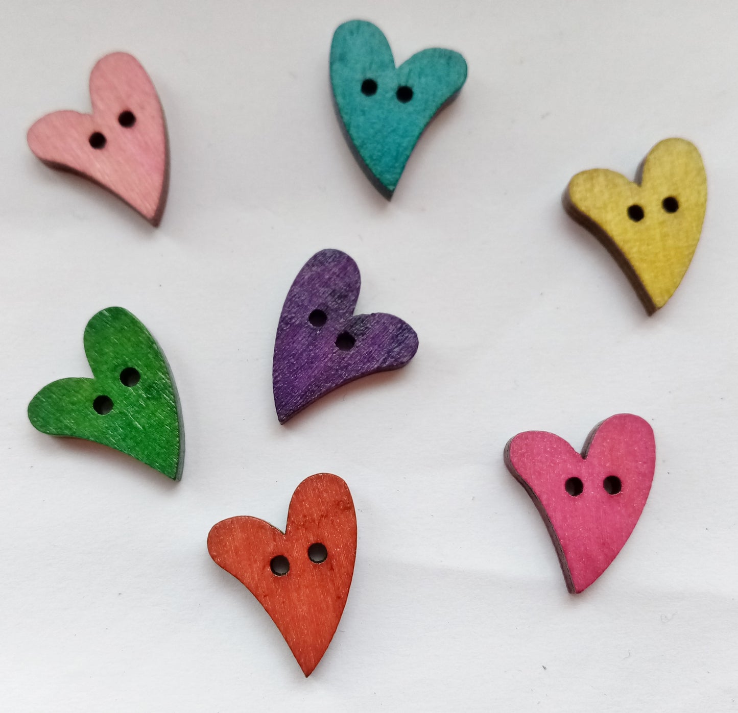 Colourful wood heart buttons measuring 15mm x 20mm.  Choose Brown, Cerise Pink, Pink, Purple, Teal or Mustard Yellow.  Pack of 10 buttons.