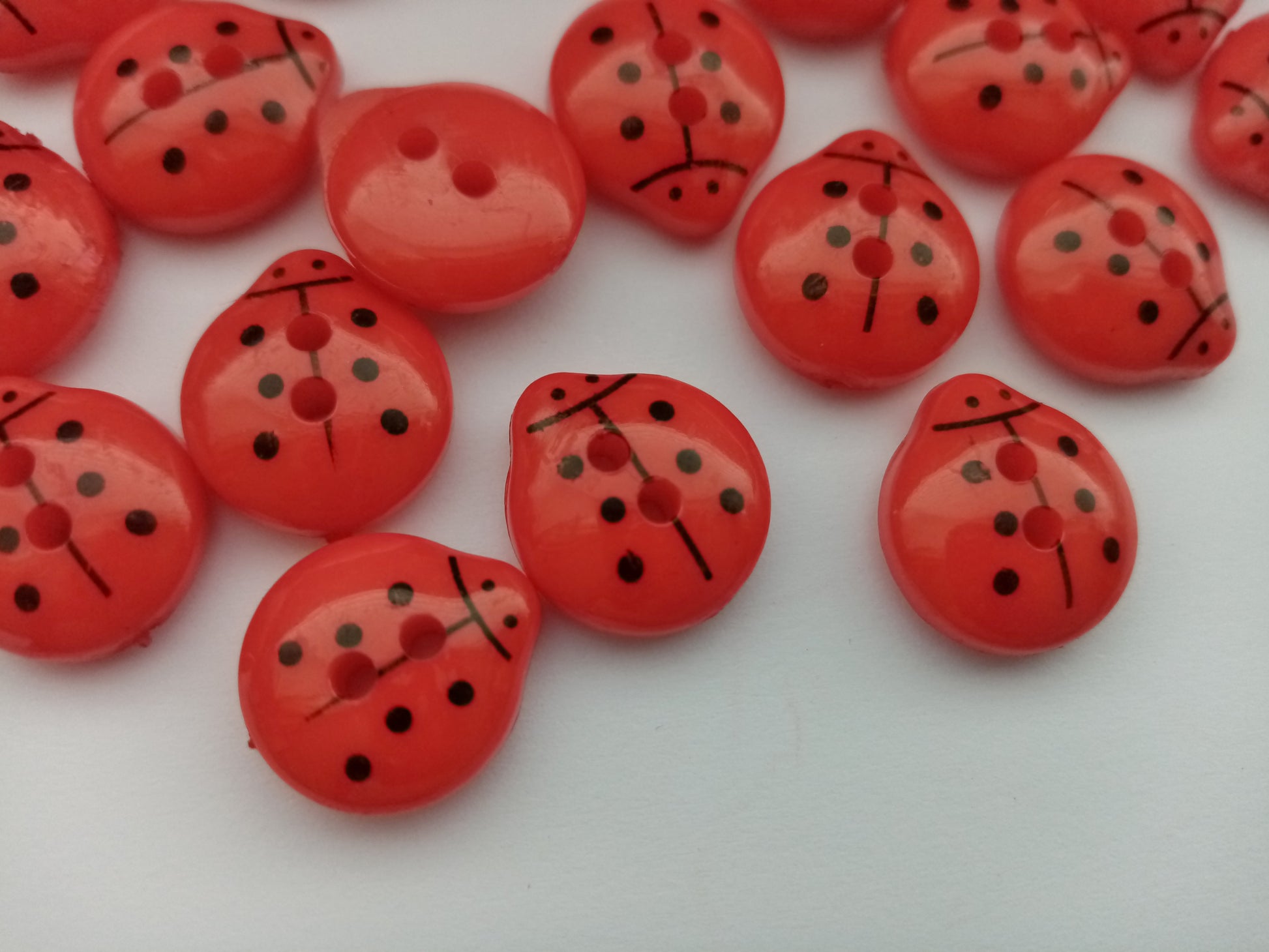 Red Ladybird sewing buttons 15mm long and 13mm wide.  Flat button with 2 holes.